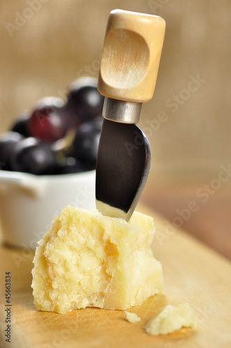 Parmesan cheese and grapes on a chopping board