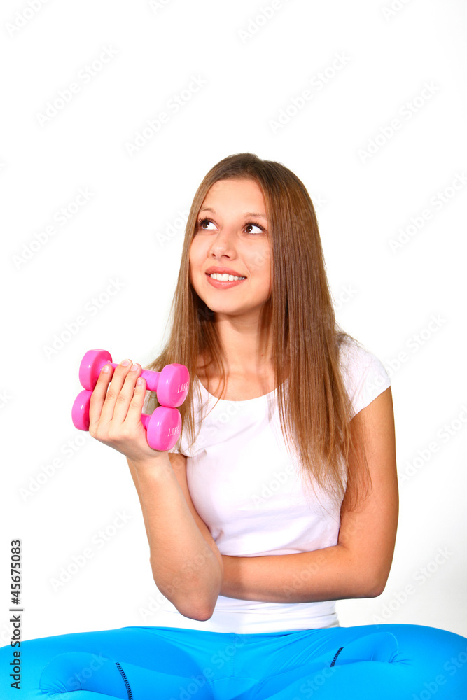 Sitting smiling young woman with dumbbells isolated on white bac Sitting smiling young woman with dumbbells isolated on white bac
