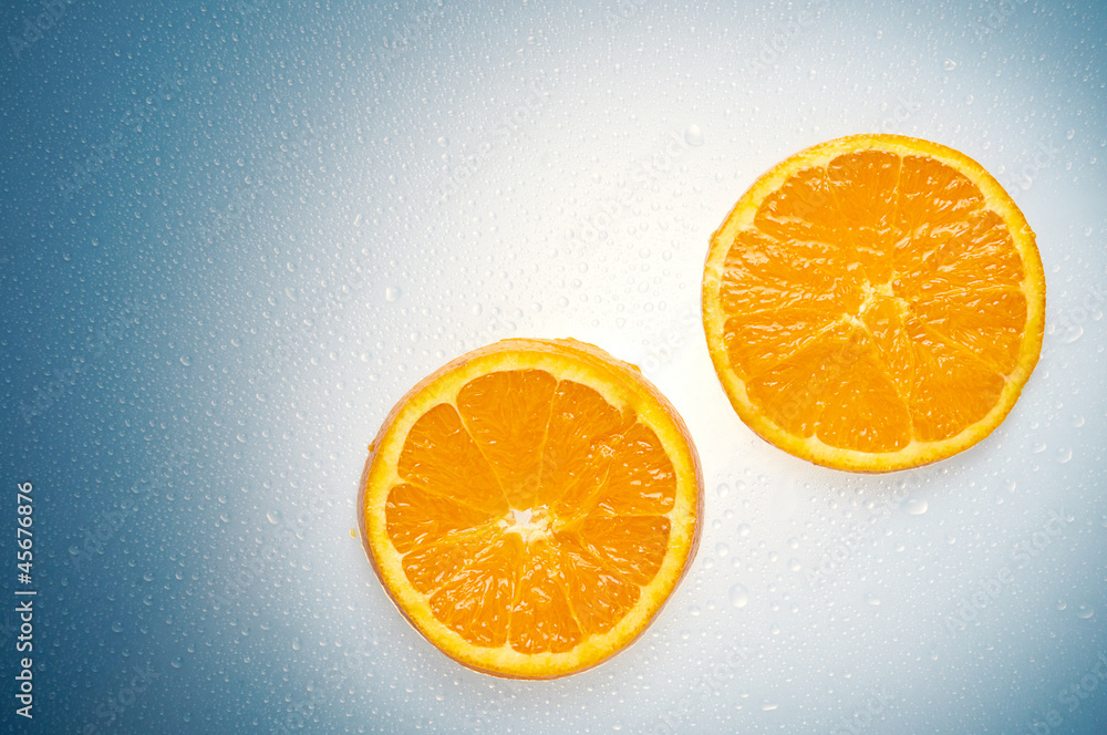 Two oranges over a white and blue wet background with water drop Two oranges over a white and blue wet background with water drop