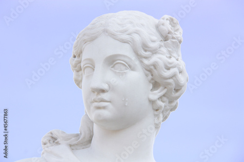 beatiful woman white marble statue face with tears on a cheek