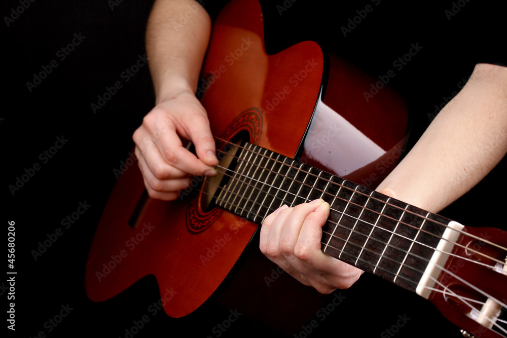 Fototapeta premium Guitar in hands isolated on black