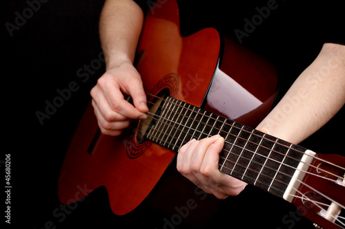 Guitar in hands isolated on black