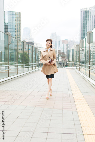 Beautiful business woman walking outside her office