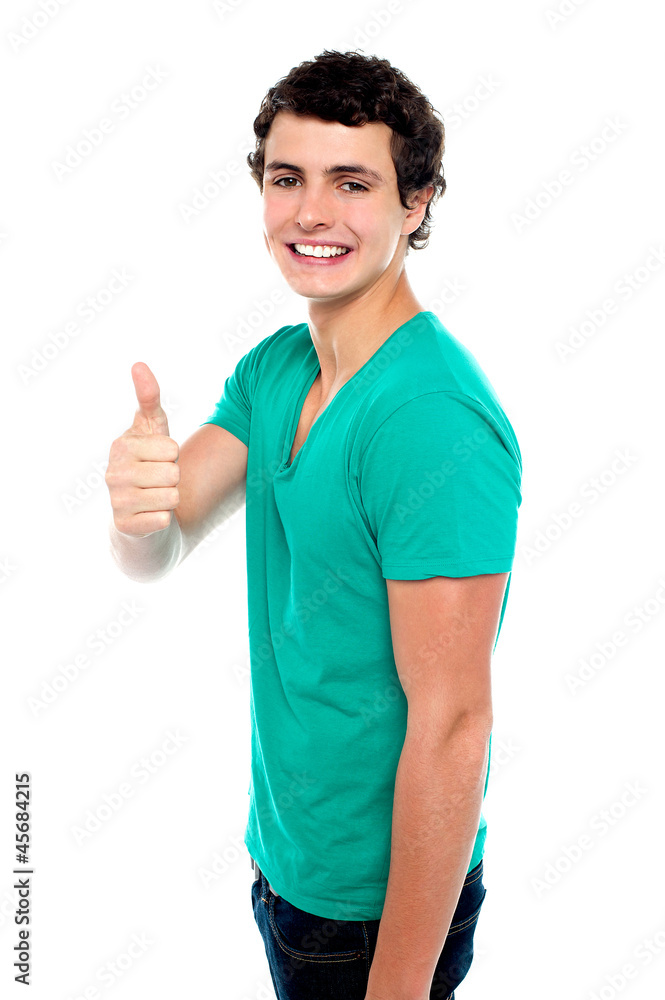 Cheerful teenager showing thumbs up to camera Cheerful teenager showing thumbs up to camera