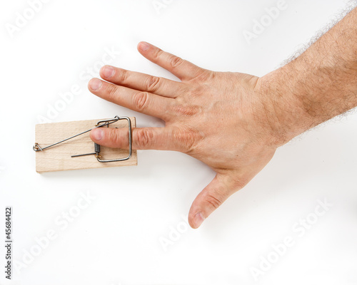 Male finger caught by mouse trap on white background