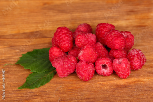 Fresh raspberries on wooden background close-up