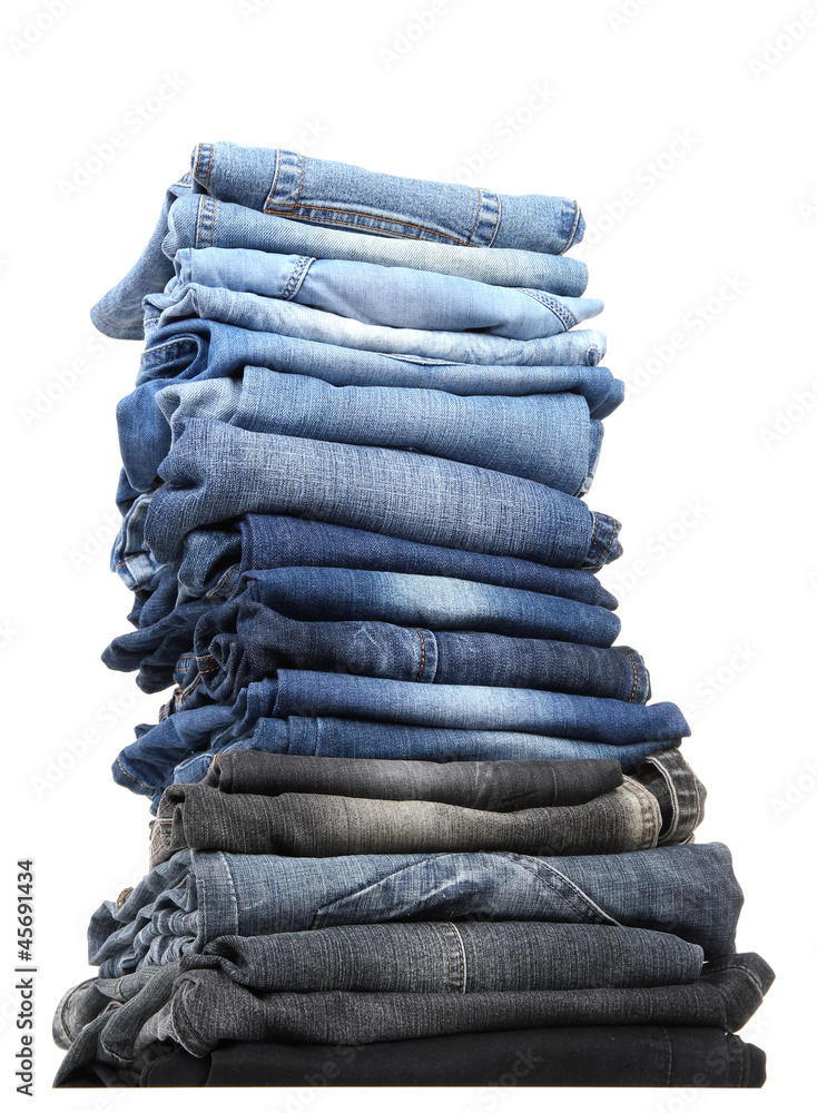 Many jeans stacked in a pile isolated on white Many jeans stacked in a pile isolated on white