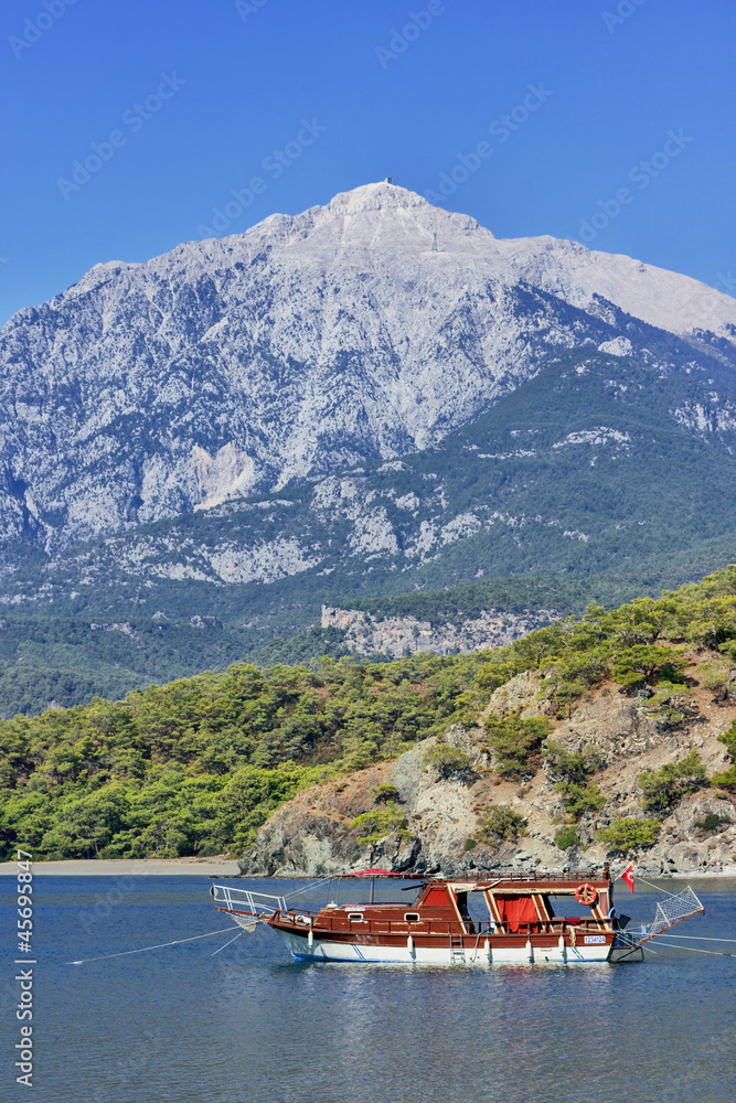 Yacht in a bay on mountains background