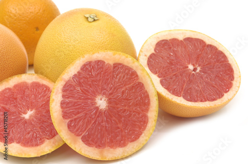 fresh grapefruit and slices on white