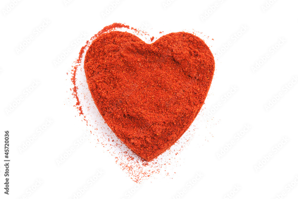 Pile of ground Paprika isolated in heart shape on white backgrou