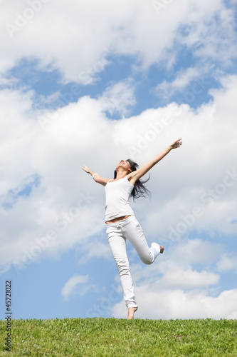 Pretty young woman jumping on green grass © Dmytro Sunagatov