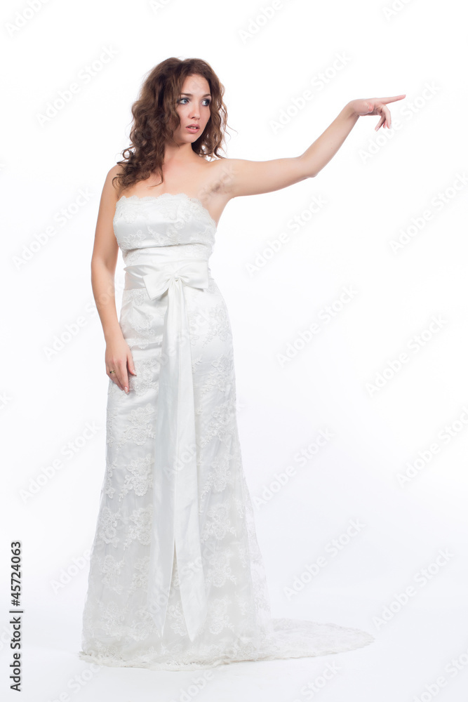 Молодая женщина в свадебном платье указывает направление