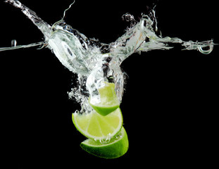 Deken met foto Opspattend water Sliced lime in the water on black background  © Africa Studio