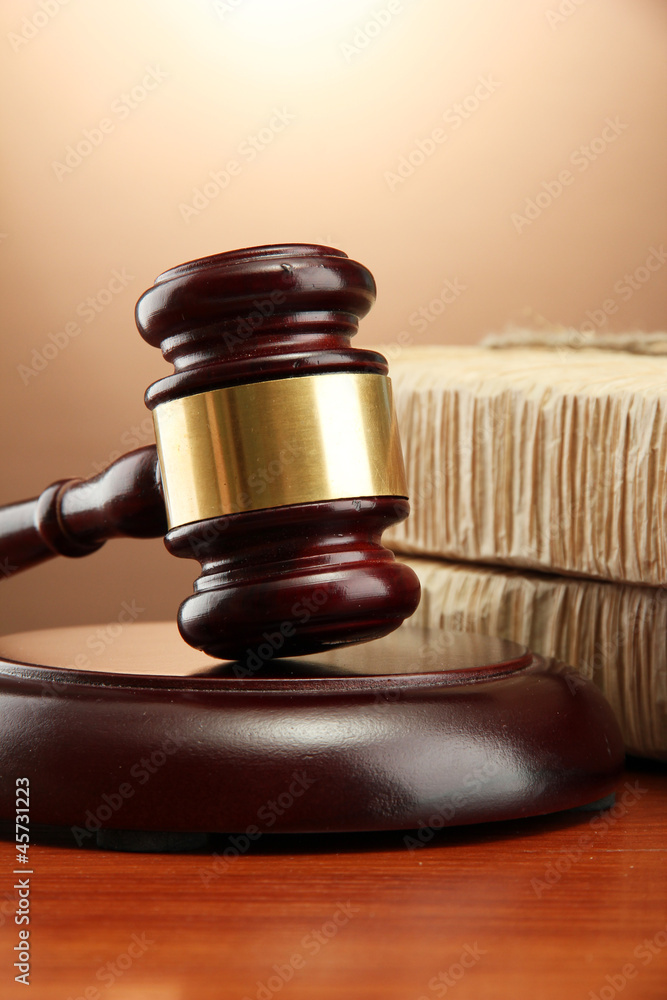 wooden gavel and books on wooden table, on brown background wooden gavel and books on wooden table, on brown background