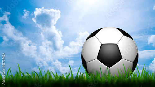 3D football in green grass on blue sky © jakgree