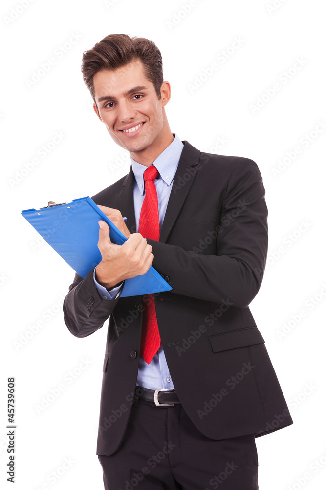 Business man smiling and writing on clipboard Business man smiling and writing on clipboard
