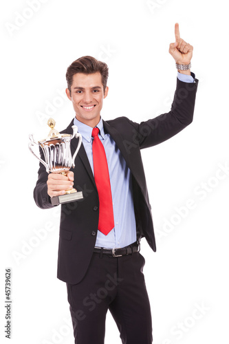 Happy business man holding a trophy