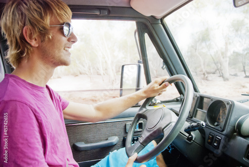 Young man driving car smiling