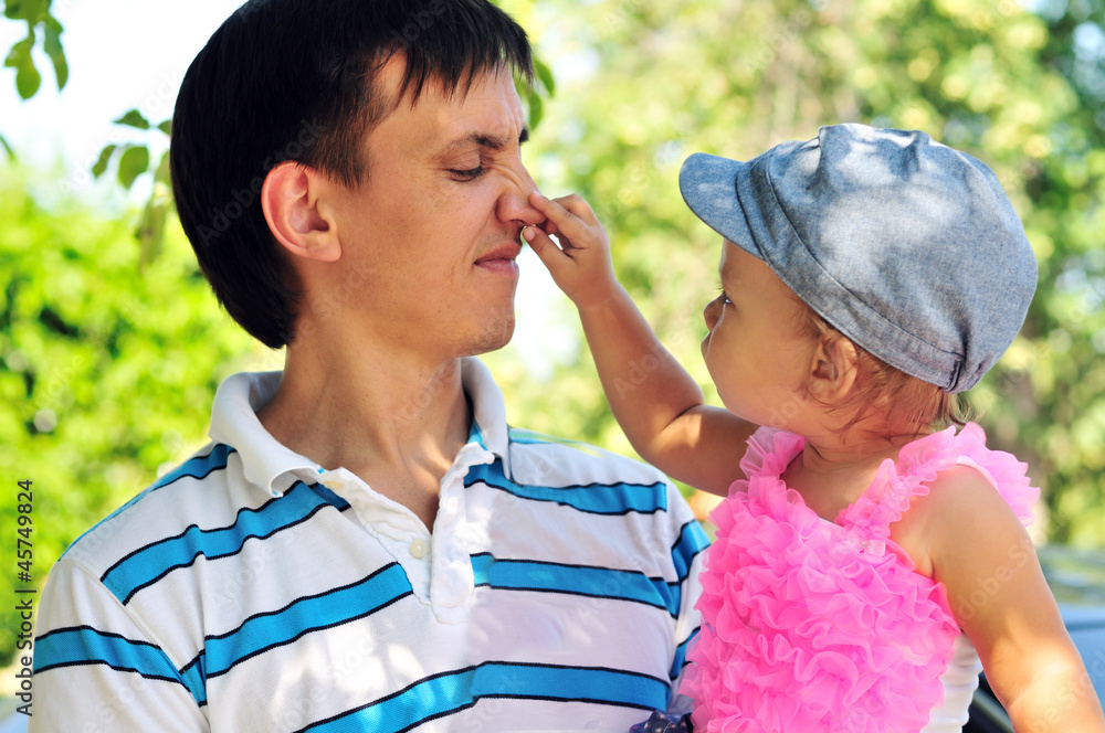 baby girl showing father's nose outdoors baby girl showing father's nose outdoors