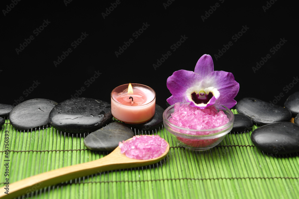 candle with zen stone and sea salt in spoon on green mat candle with zen stone and sea salt in spoon on green mat