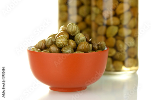 green capers in ceramical bowl on white background photo