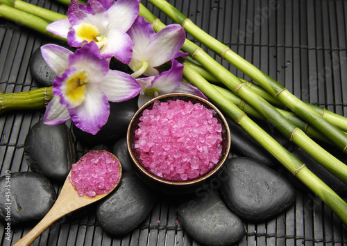 Pink salt in bowl with thin bamboo grove and orchid on mat