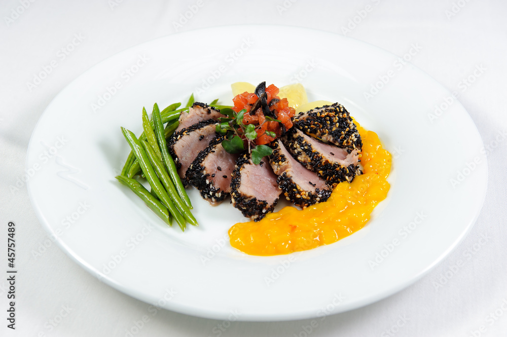 Cuts of meat with vegetables and sauce on a plate