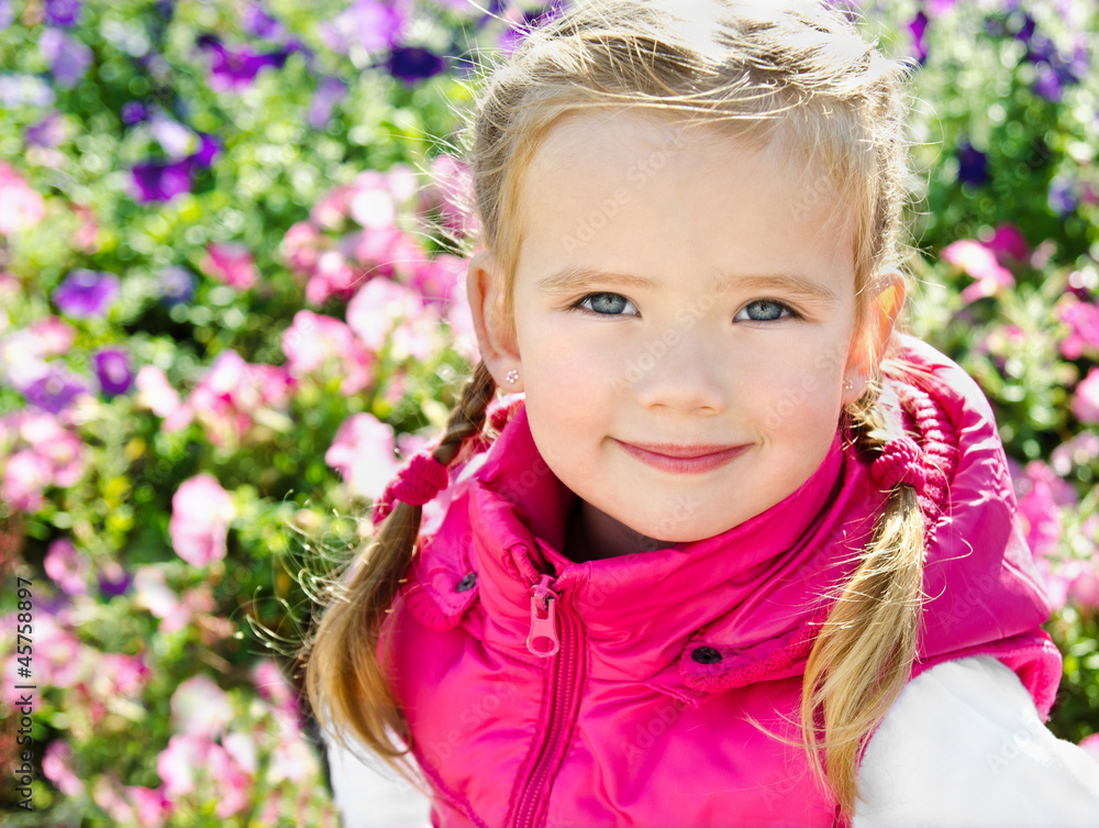 Outdoor portrait of cute little girl near the flowers Outdoor portrait of cute little girl near the flowers