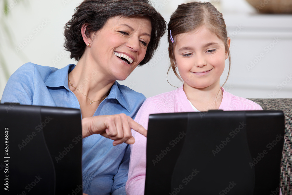 Mother and daughter having fun with their laptops Mother and daughter having fun with their laptops