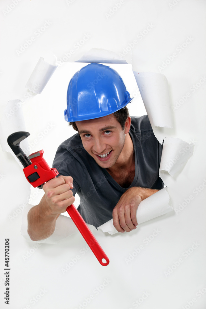 Young worker passing through a wallpaper Young worker passing through a wallpaper
