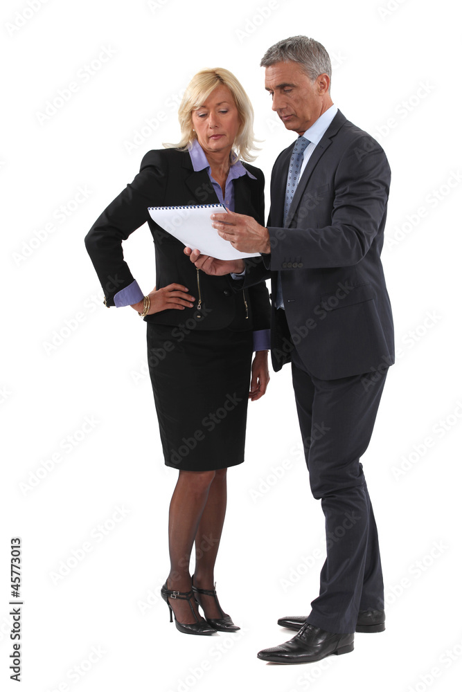 Mature business couple discussing a document Mature business couple discussing a document
