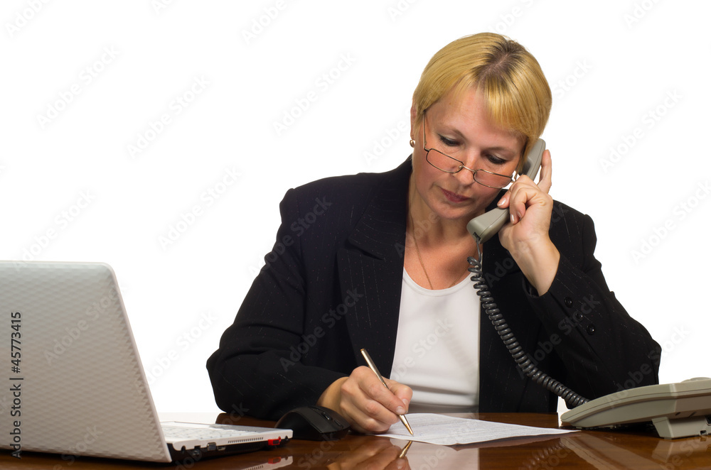 Mature businesswoman calling on the phone at her workplace. Mature businesswoman calling on the phone at her workplace.