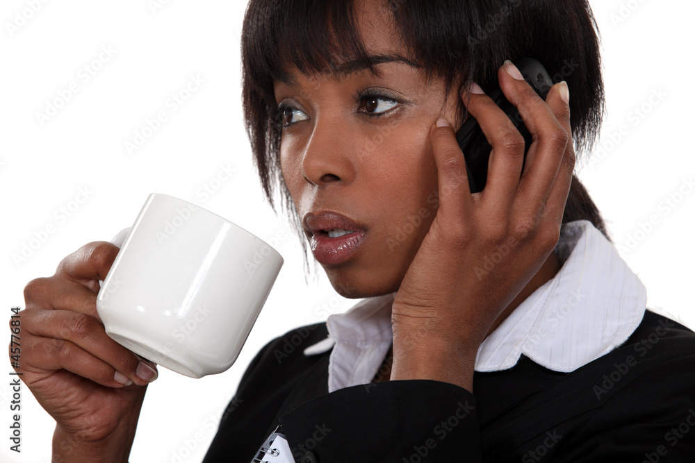 businesswoman drinking coffee and talking on her cell businesswoman drinking coffee and talking on her cell