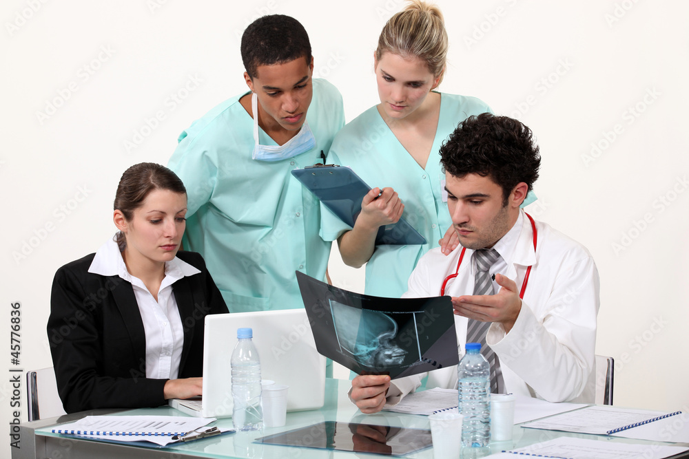 young physician surrounded by male and female nurse young physician surrounded by male and female nurse