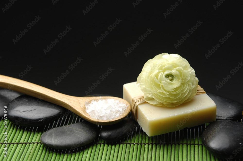 ranunculus on soap and salt in bowl on green mat