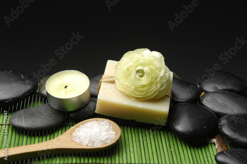 salt in bowl with candle with ranunculus on soap on green mat