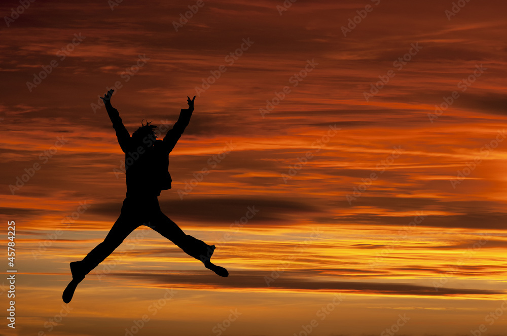 Girl jumping with joy at sunset - clipping path included