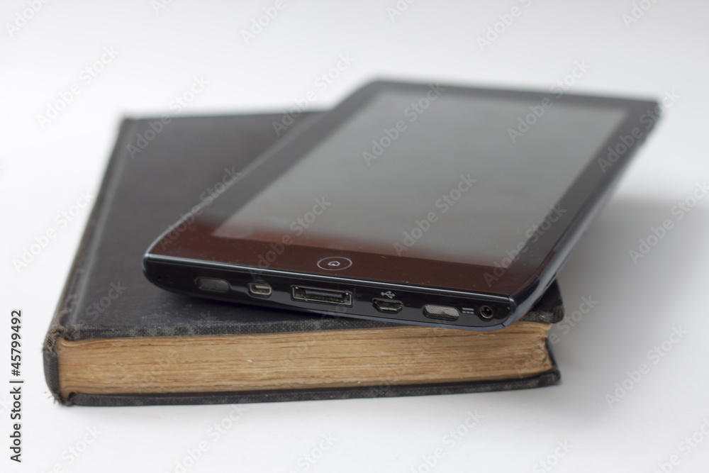 tablet atop book against white background tablet atop book against white background