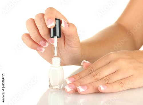 Woman makes herself a French manicure  on white background