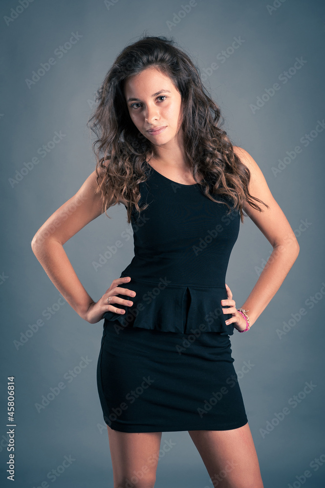 Beautiful girl with black dress against dark background. Beautiful girl with black dress against dark background.