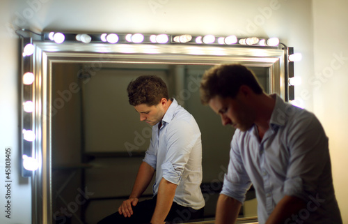 Homme pensif près d'un miroir
