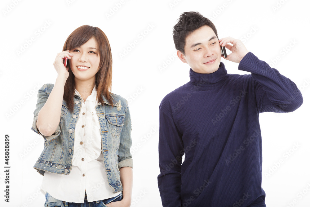 Obraz premium Young couple talking on mobile phone isolated on white