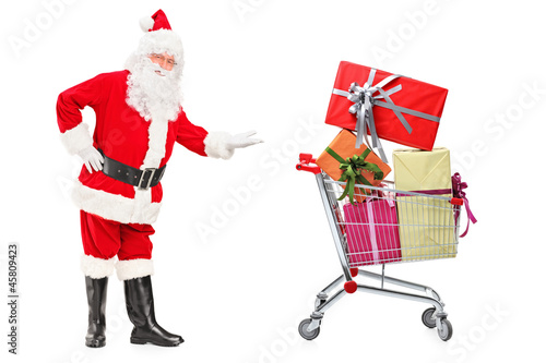 Santa Claus showing a shopping cart full of presents © Ljupco Smokovski