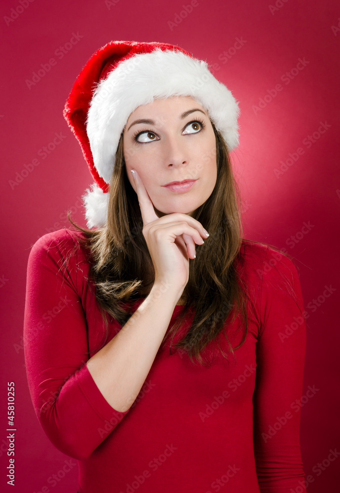 Beautiful young woman with santa hat thinking Beautiful young woman with santa hat thinking