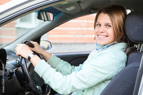 Driving happy woman holding steering wheel © Kekyalyaynen