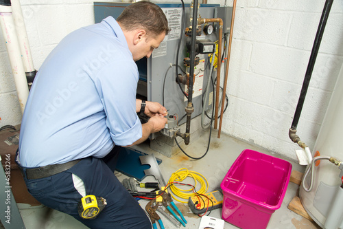 Plumber repairs furnace