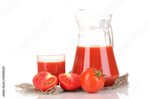 Tomato juice in pitcher and glass on sackcloth isolated on