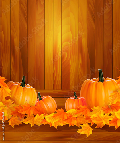 Pumpkins on wooden background with leaves.