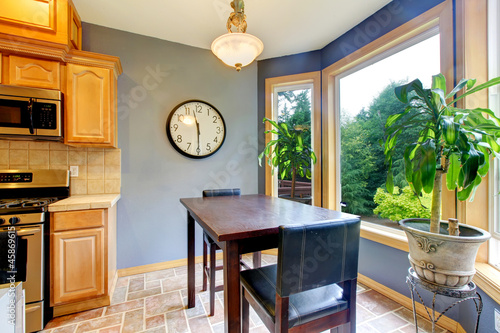 Dining breakfast table near the kitchen with blue walls. photo