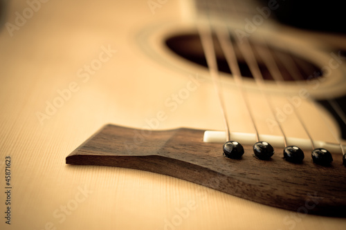 Macro shot down the fretboard of acoustic guitar with shallow de